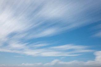 Wide open sky over Brasília with a bright ascending horizon and a small sun dot, reflecting the 'céu em movimento' visual concept.