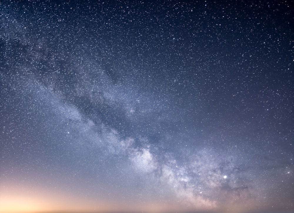 a starry night sky with a few clouds