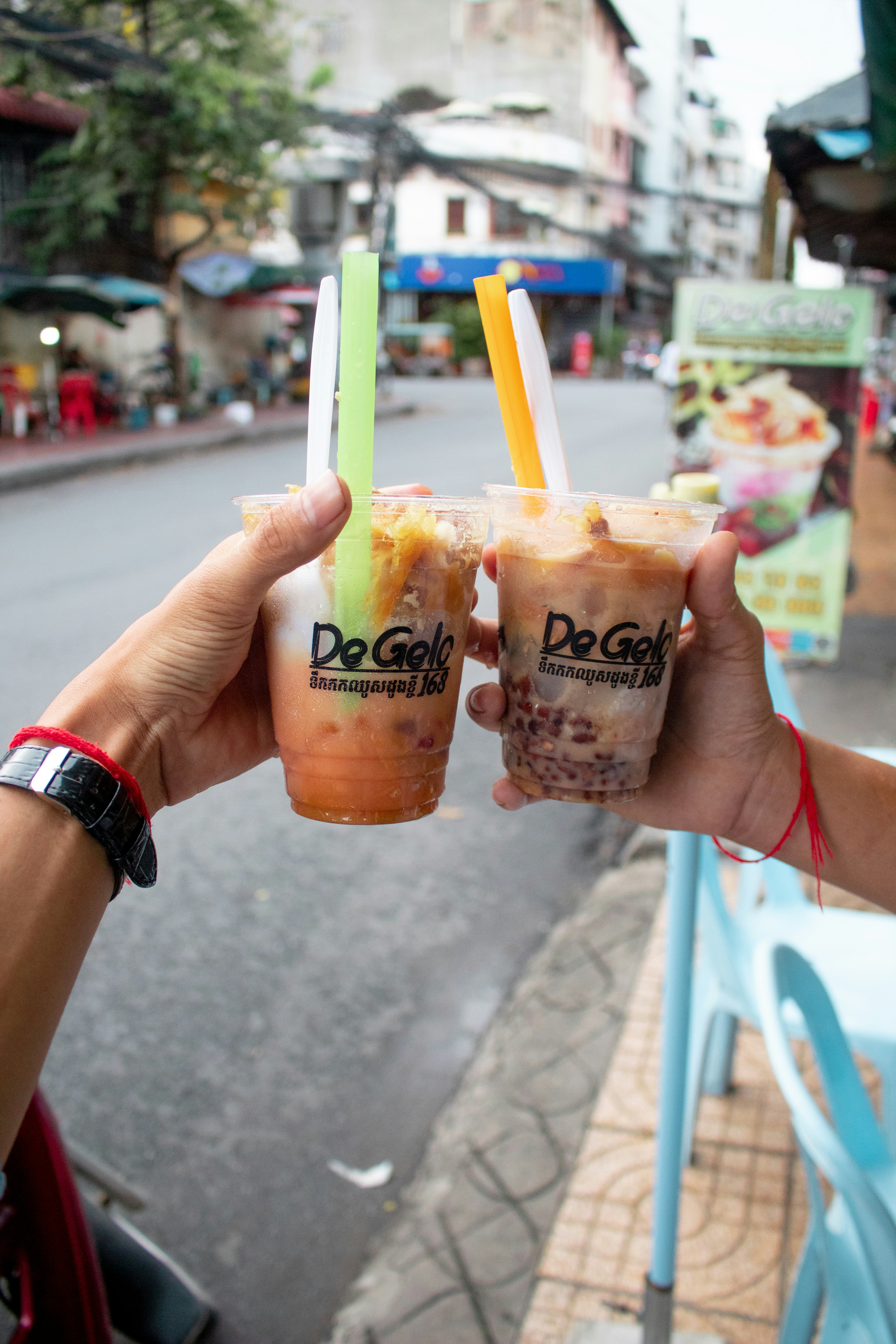 a person holding two cups of ice cream