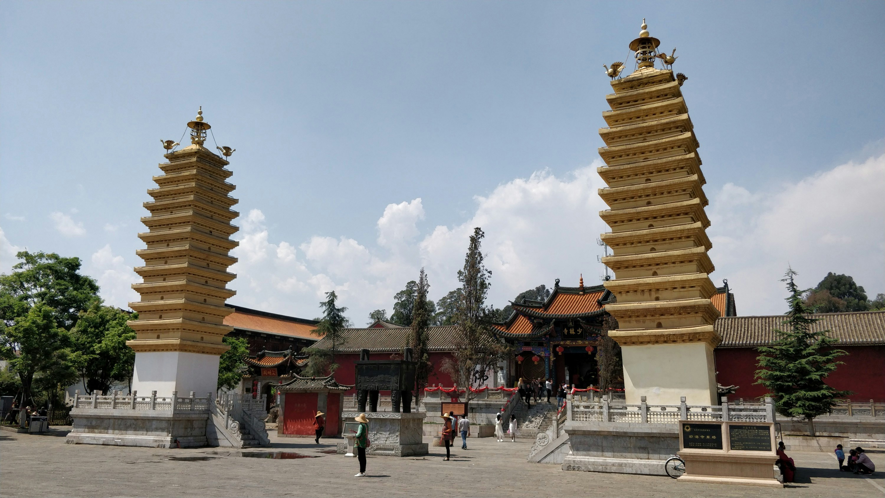 a group of people outside of a building with towers