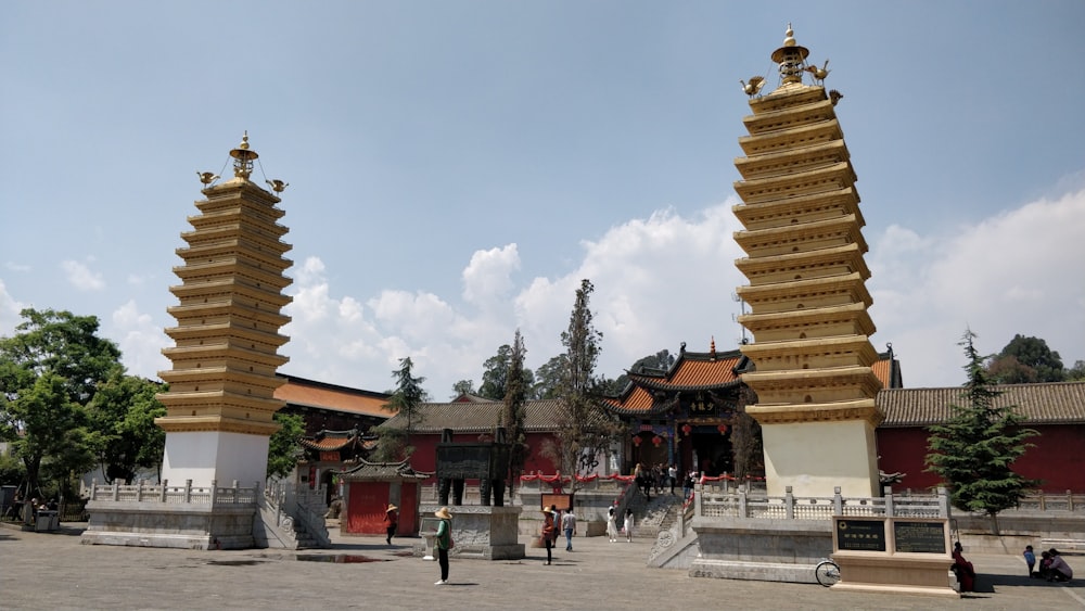 a group of people outside of a building with towers