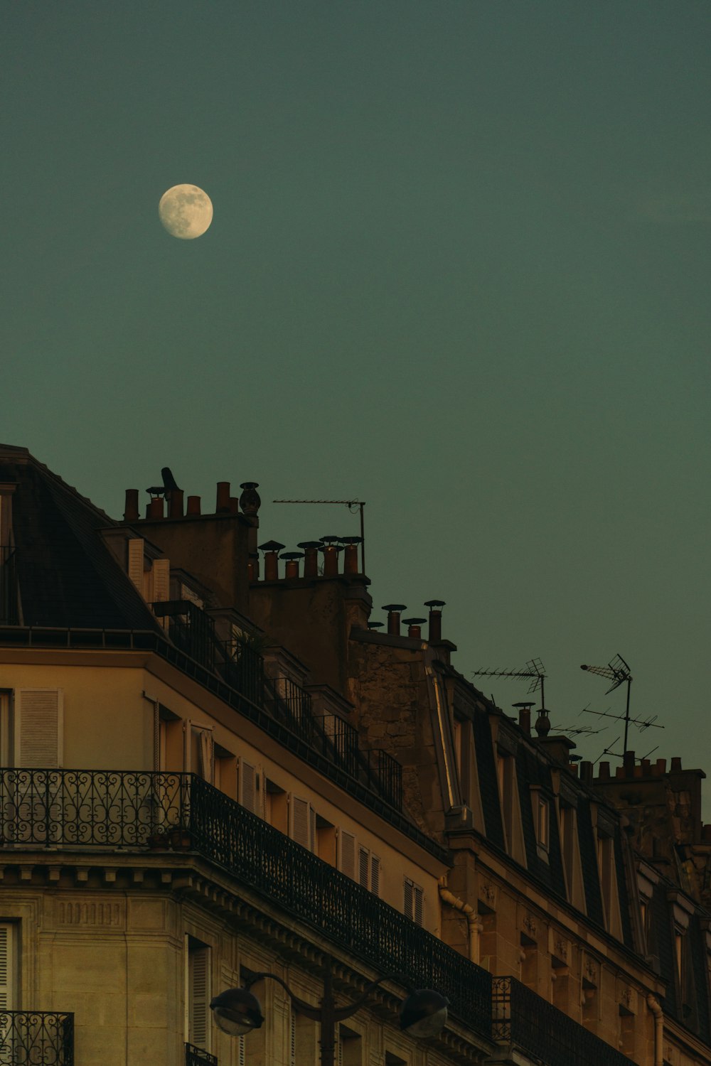 a moon in the sky over buildings