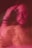 A blurred, artistic portrait of a person with a contemplative expression. The colors are predominantly pink and red, and the double exposure effect creates a sense of motion and ambiguity.