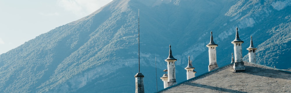 a building with towers and a mountain in the background