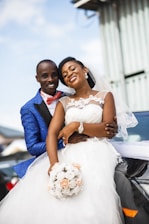 A joyful wedding couple taking fun photos in a photobooth with colorful props.