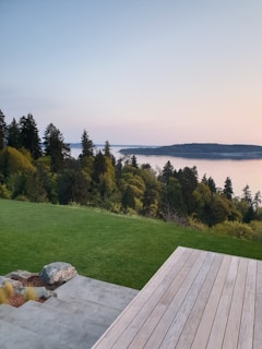 A family enjoying a peaceful moment on the wooden deck of their cottage surrounded by lush greenery.