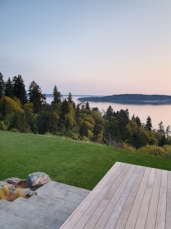 A family enjoying a peaceful moment on the wooden deck of their cottage surrounded by lush greenery.