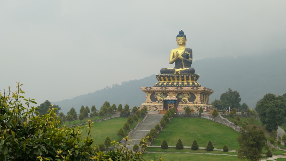 a large gold statue on a hill