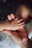 A small baby hand resting in the palm of an adult hand