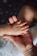 A small baby hand resting in the palm of an adult hand