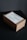 A cardboard box is placed on a dark surface. The box has a label on top with text related to personal delivery. Soft lighting creates subtle shadows around the box, emphasizing its shape and texture.