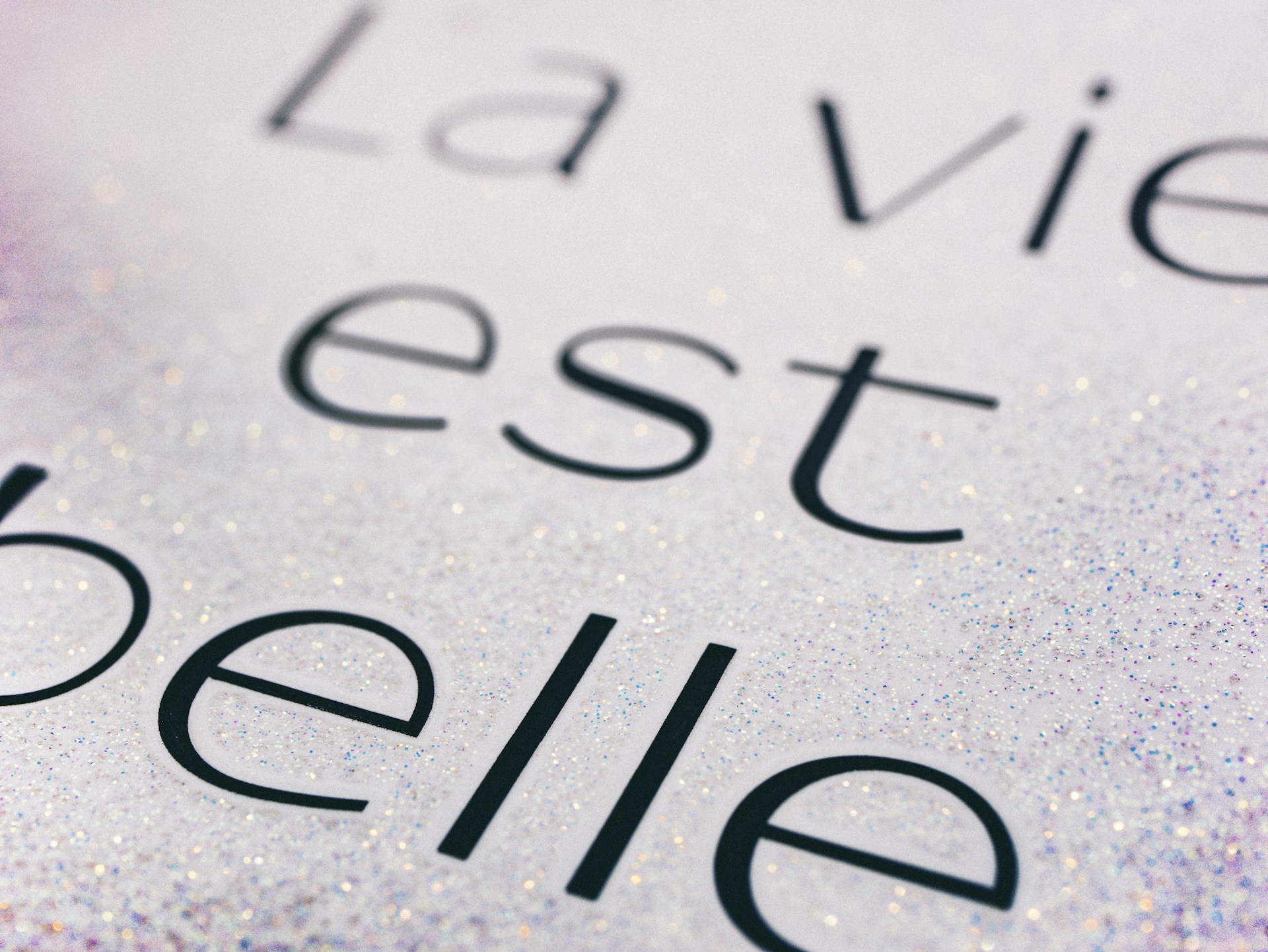 A smooth horizontal scrolling text animation on a dark background, showing dynamic looping phrases in French.