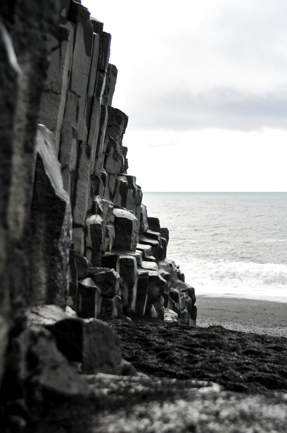 a cliff side with a body of water in the background