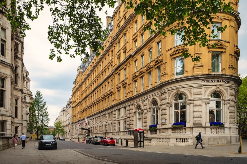 a street with cars and people on it next to a building