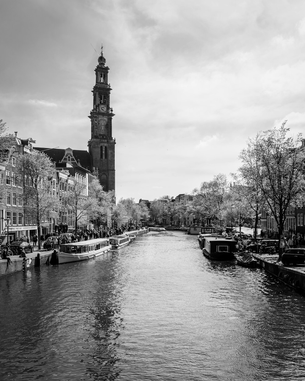 Ein Fluss mit Booten darauf und ein hohes Gebäude im Hintergrund