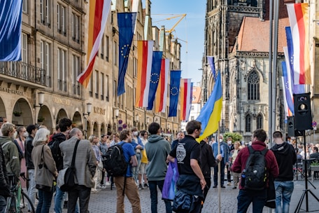 a group of people walking on a street with flags