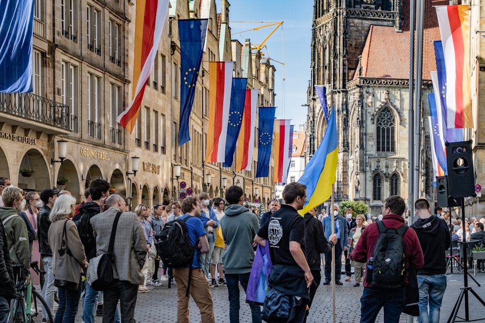 a group of people walking on a street with flags