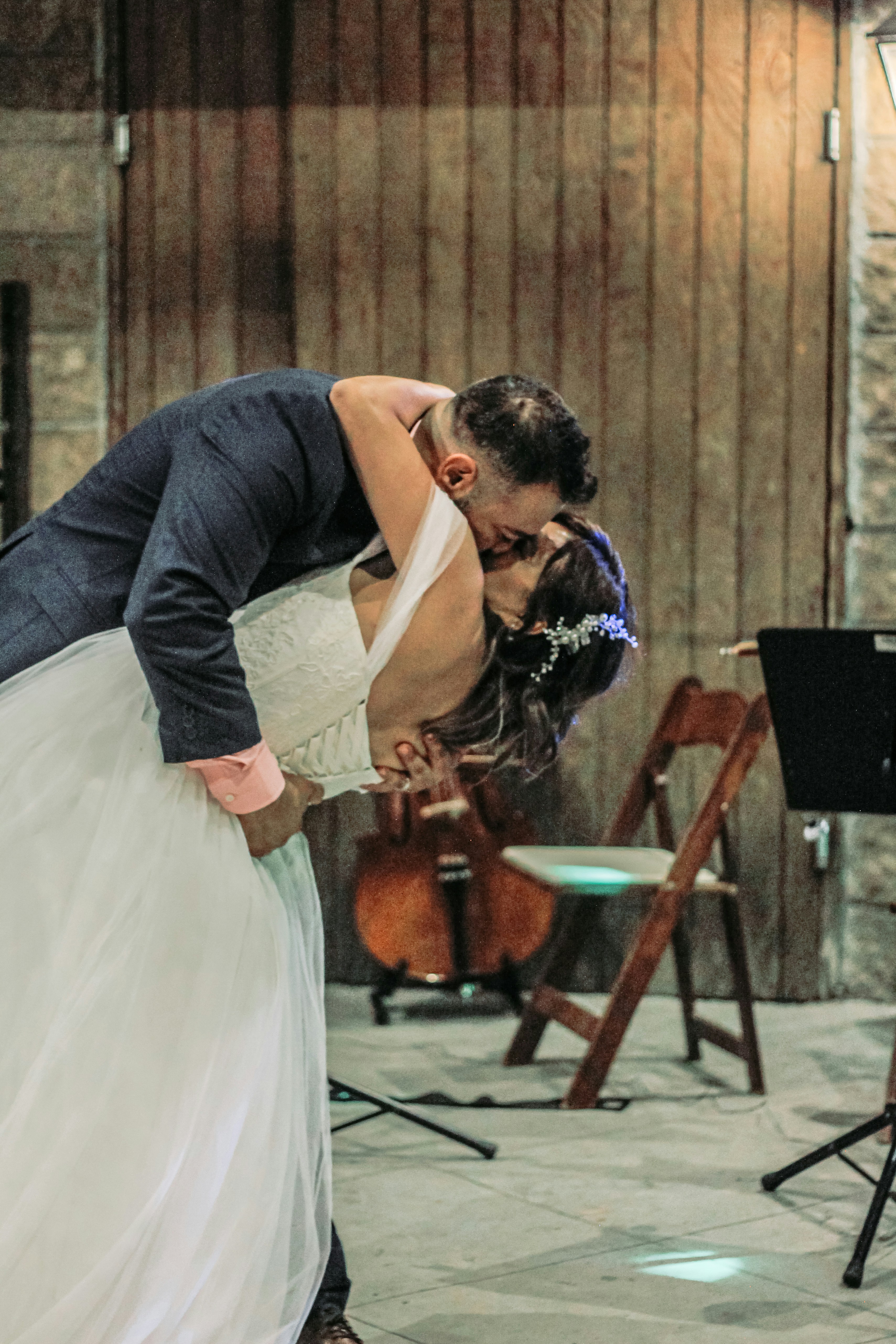 Groom dipping bride dramatically, both laughing