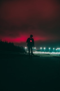a person standing on a road with a fire in the background