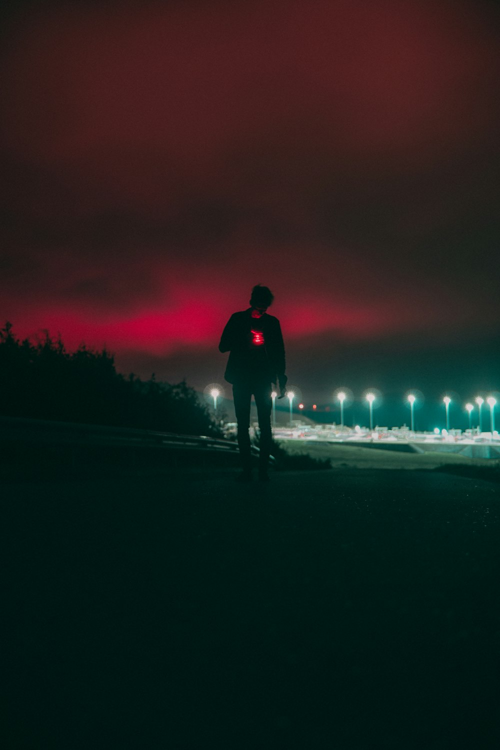 a person standing on a road with a fire in the background