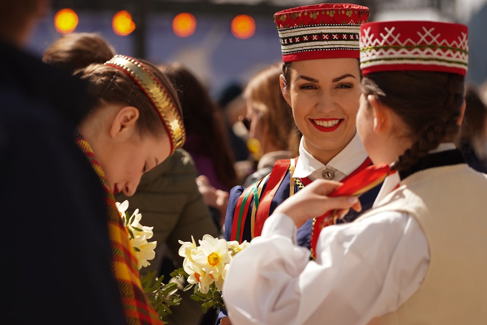 a couple of girls wearing red and white hats and smiling