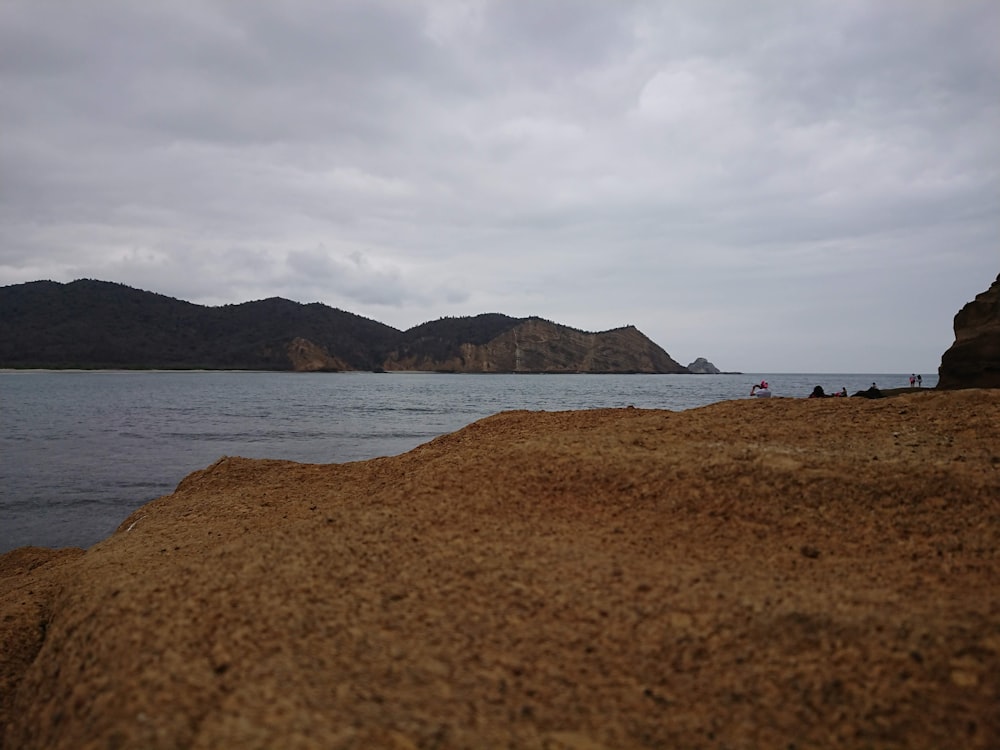 a rocky beach with a body of water in the background