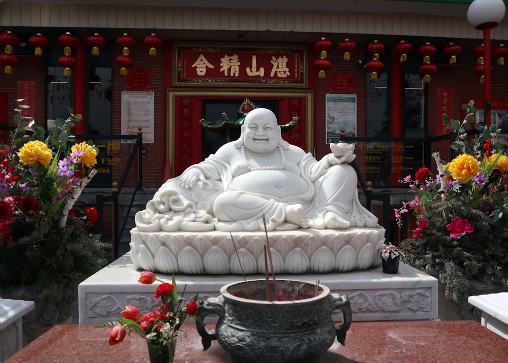 a statue of a person sitting on a bench in front of a building