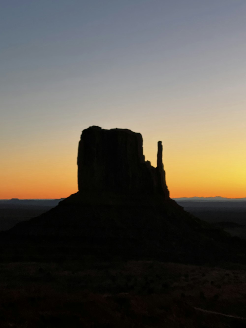 a large rock formation with a sunset in the background