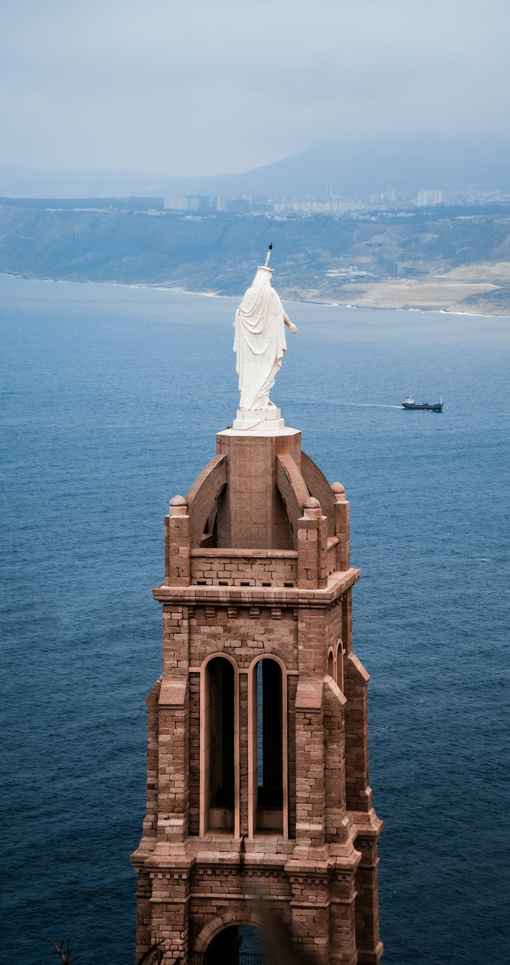 a tall tower with a statue on top of it