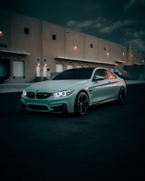 A sleek luxury truck parked beside a modern warehouse under soft evening light.