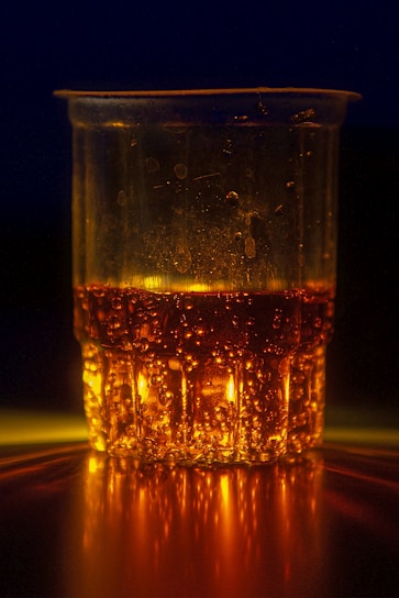 Magic Cup filled with glittering liquid, softly glowing under natural light on a white wooden table.