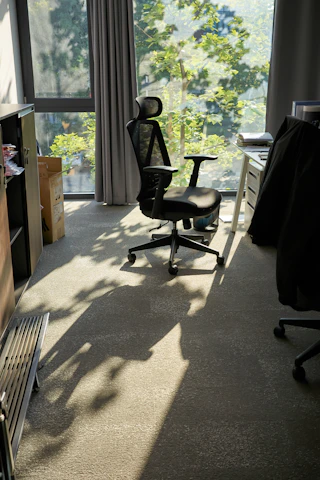 A comfortable bifma-certified office chair positioned by a window with natural light.