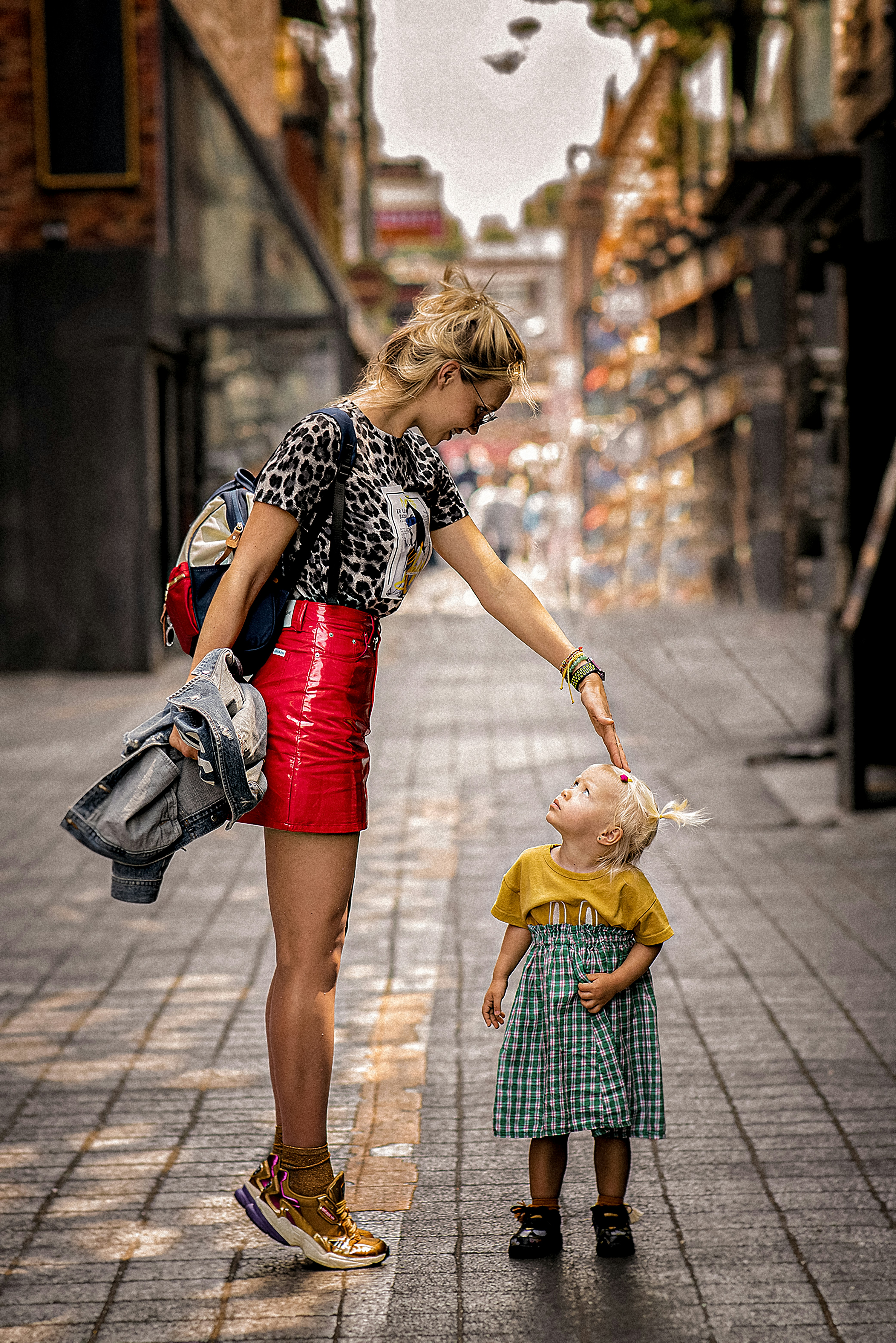 a woman and a child walking on a sidewalk