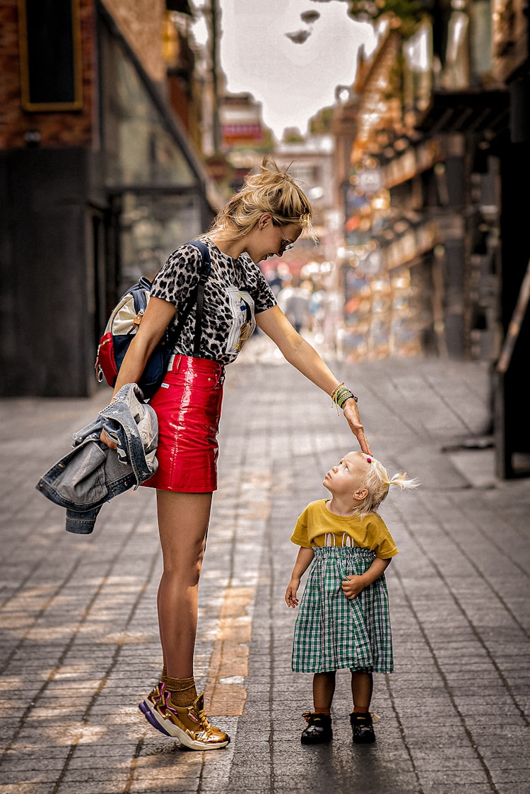 a woman and a child walking on a sidewalk