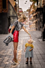 a woman and a child walking on a sidewalk