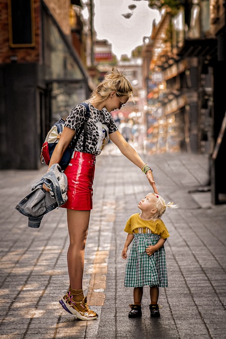 a woman and a child walking on a sidewalk
