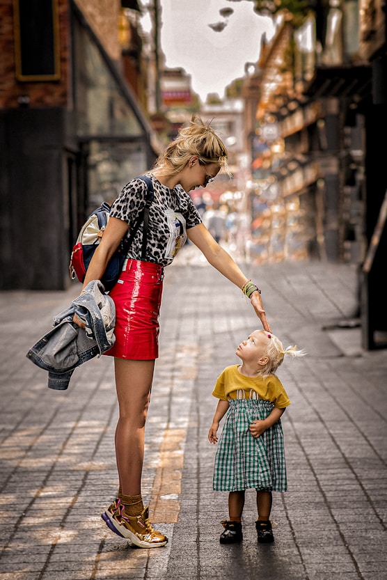 a woman and a child walking on a sidewalk