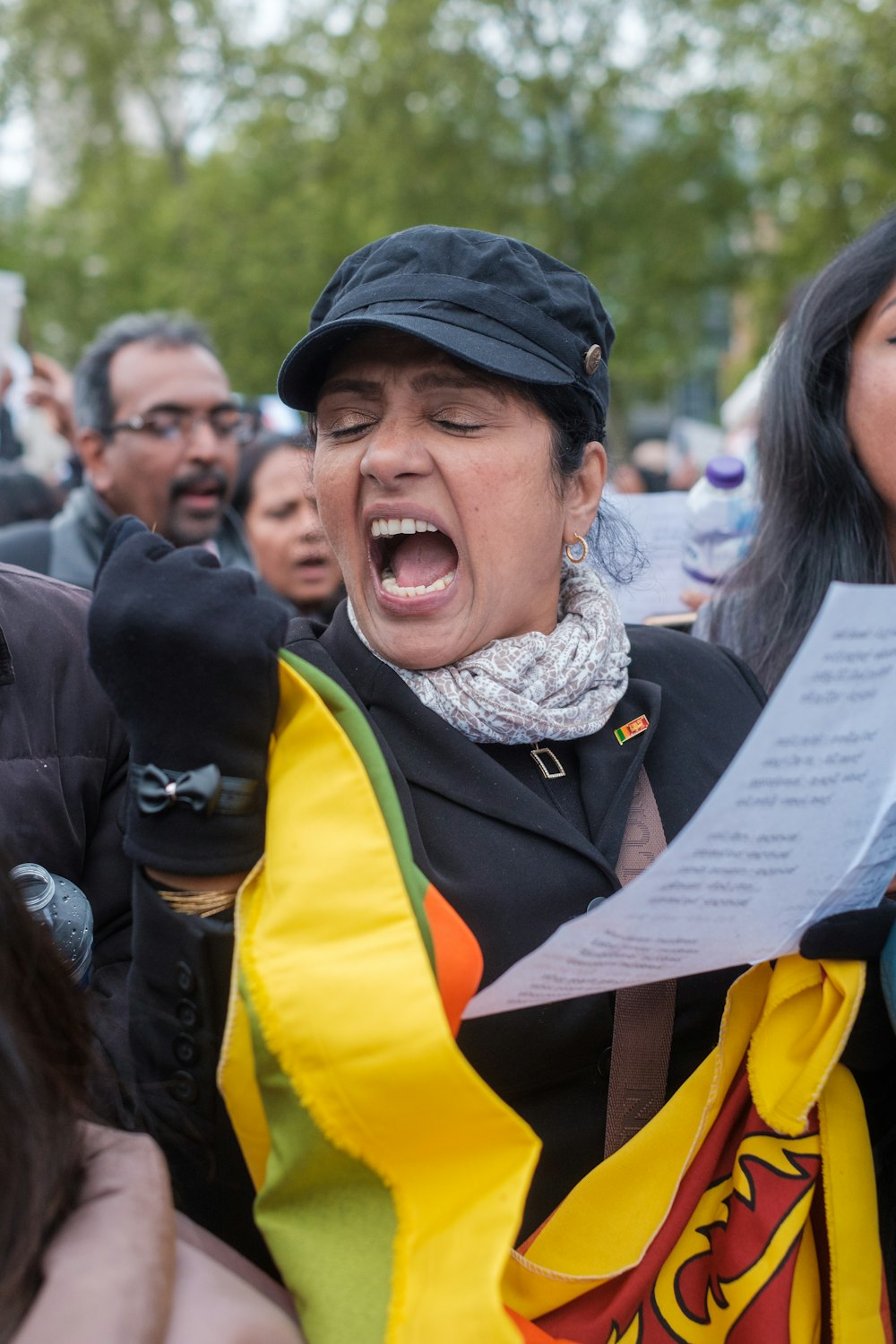 a person with a hat and a scarf holding a sign