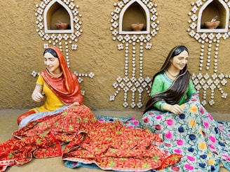 two women sitting on a bed
