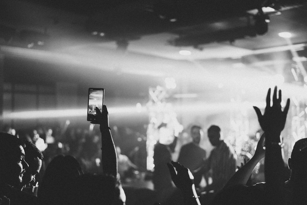 a crowd of people holding up their hands