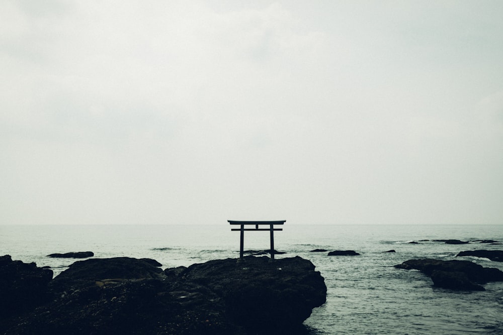 a bench on a rocky beach