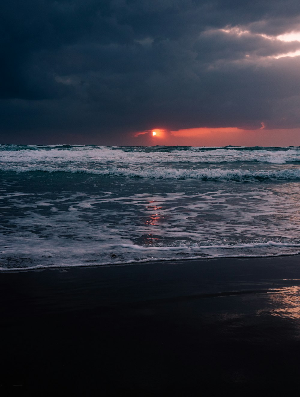 a beach with waves and a sunset