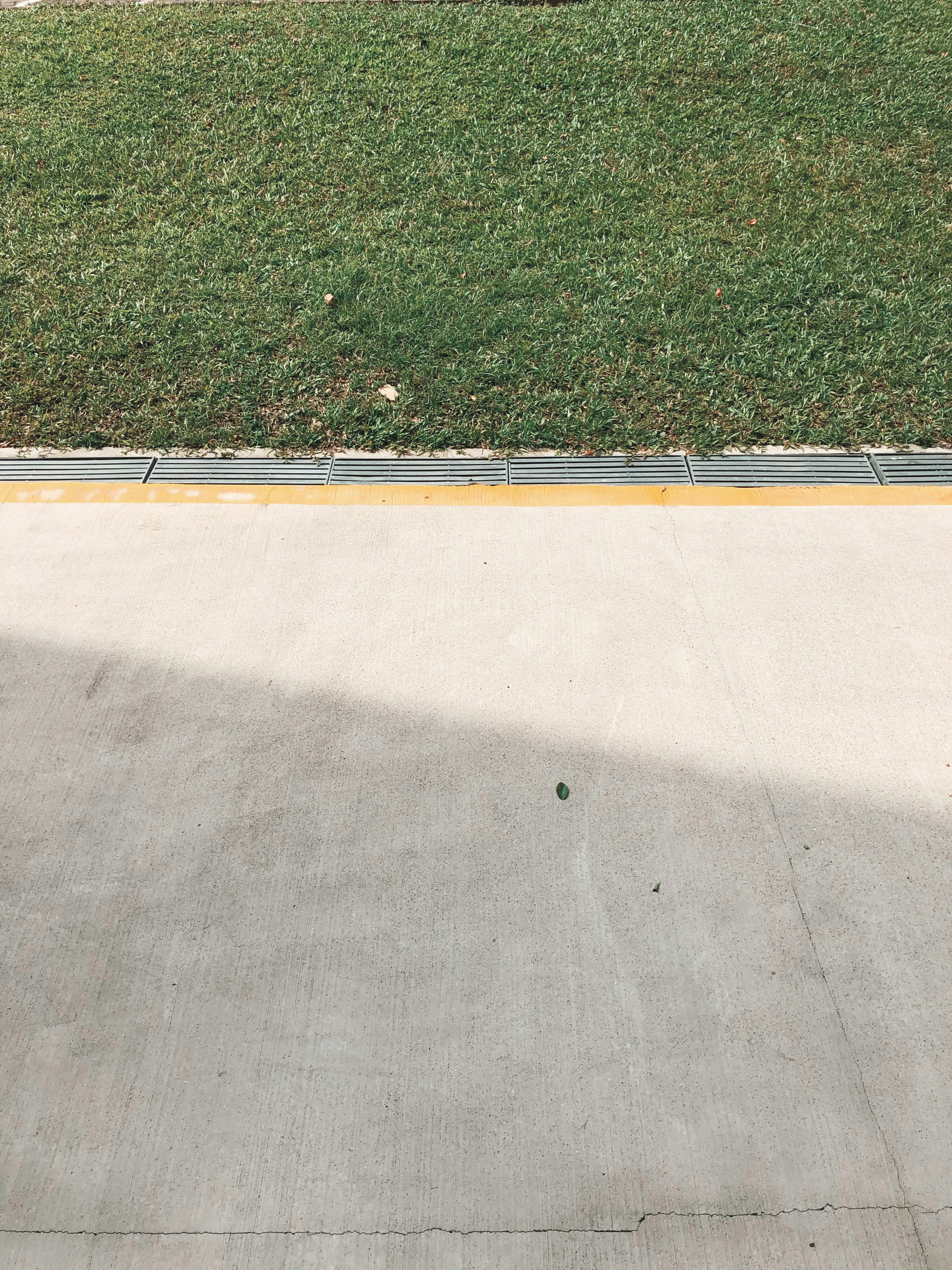 A concrete area with grass and a fence photo Free Plant Image on Unsplash