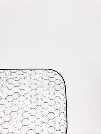 Close-up of durable galvanized wire mesh and fiberglass mesh rolls stacked outdoors.