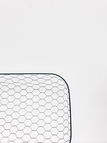 A close-up photo of sturdy wire mesh netting rolled neatly in a warehouse.