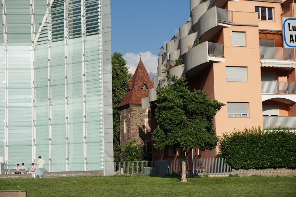 a group of buildings with trees and grass in front of them