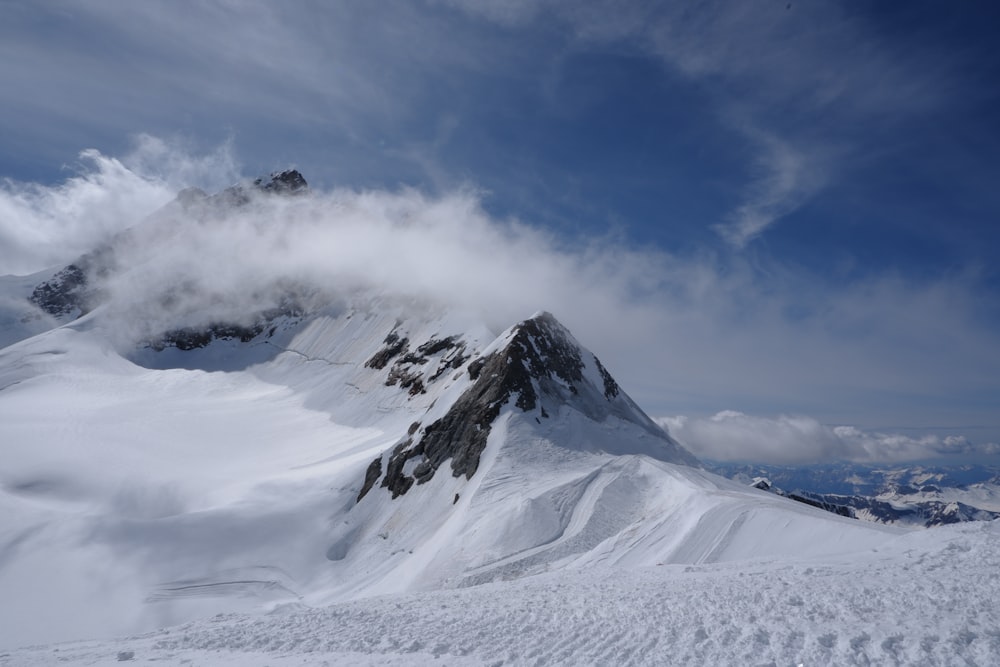 a snowy mountain with clouds