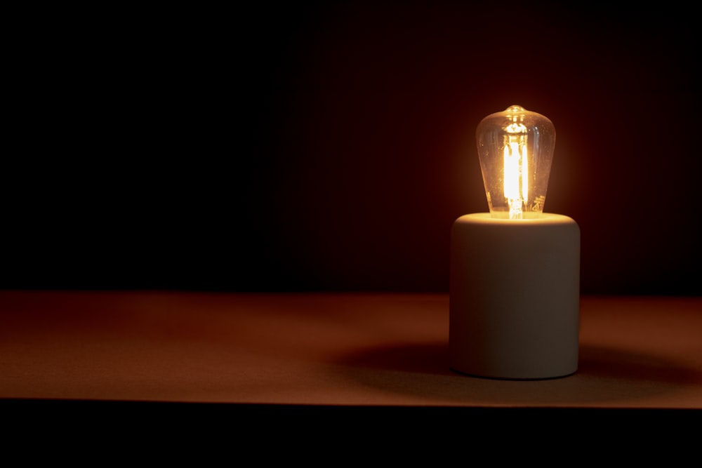 a lit candle in a dark room