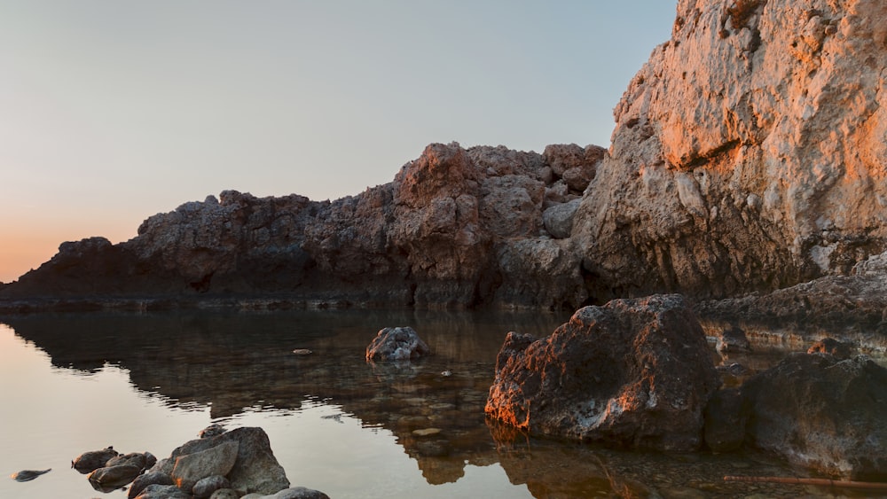 Una playa rocosa con un cuerpo de agua en primer plano