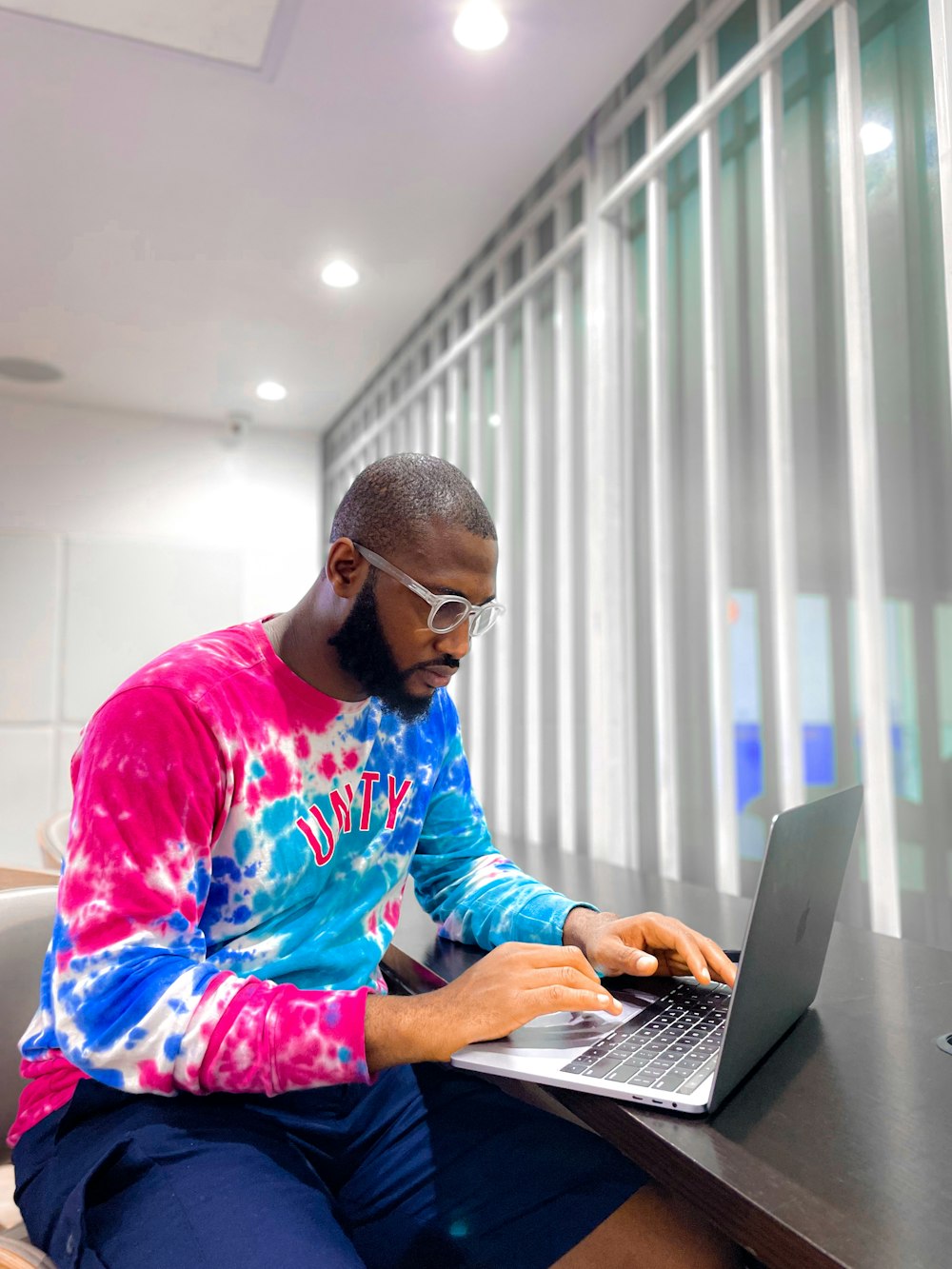 a man sitting on a chair using a laptop